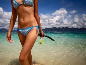 model at beach in blue bikini