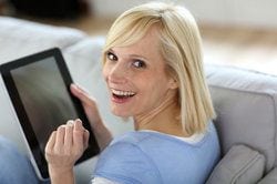 Woman sitting on a couch with a tablet