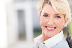 Older woman in white shirt smiling at camera