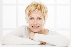 Blonde woman with resting on her arms smiling at camera