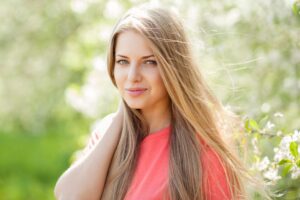 Smiling blond lady holding her hair