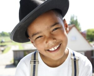 little boy smiling showing his ears under a hat