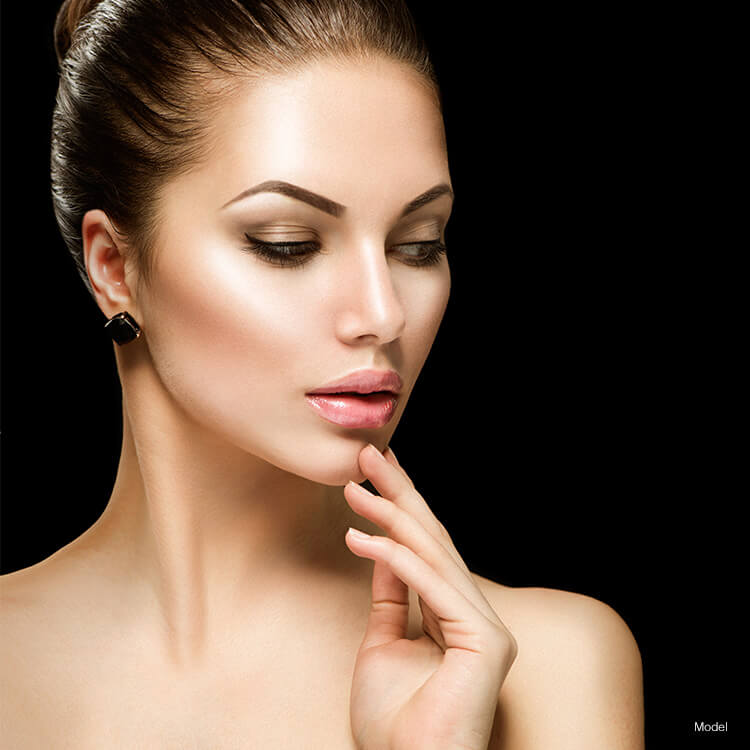 Woman touching chin on black background