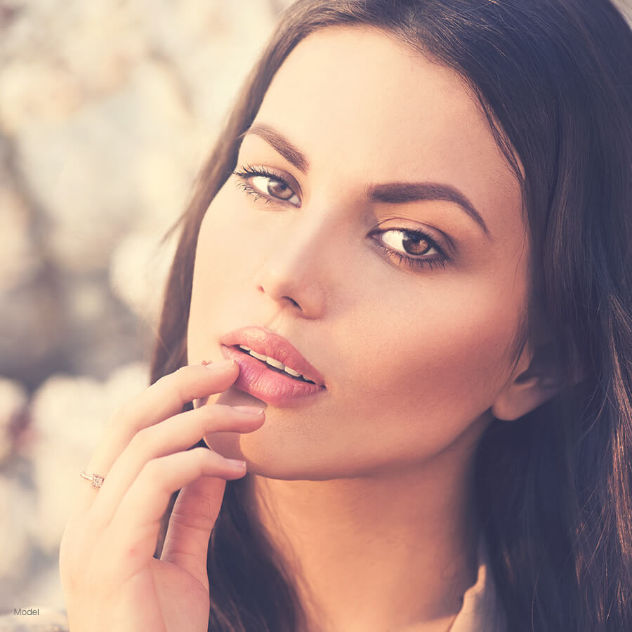 model posing with hand on lip